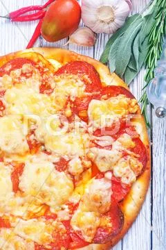 Fresh pizza with salami and cheese on a table Stock Photos