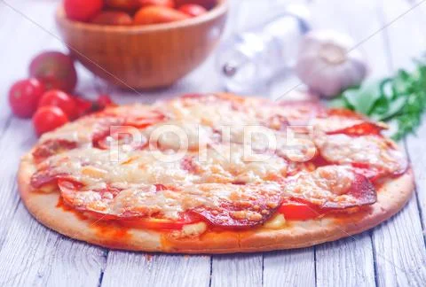 Fresh pizza with salami and cheese on a table Stock Photos