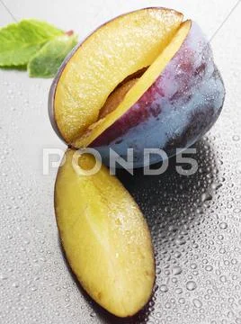 Fresh Plum, A Section Cut Out, With Drops Of Water