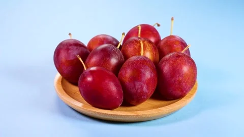 Fresh plums on a plate, rotating Stock Footage 317922838