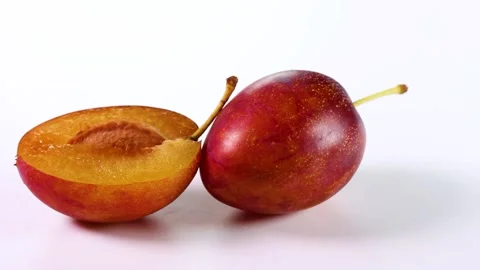 Fresh plums on white background, rotating Stock Footage 318377497