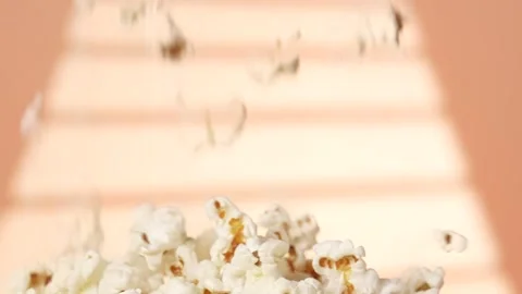 Fresh popcorn falling into a table Stock Footage 299373870