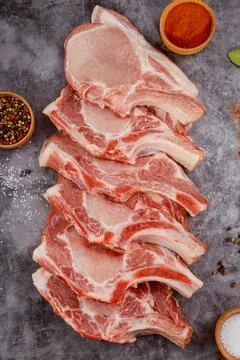 Fresh pork meat bone in on background with spices. Stock Photos