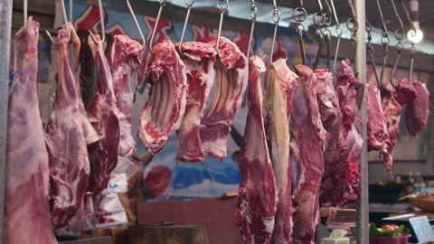 Fresh pork meat hung up in the vegetable market Stock Footage 322776950