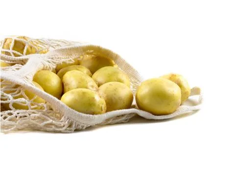Fresh potatoes in a string bag on a white background. Stock Photos
