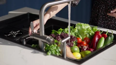 Fresh produce being washed in a kitchen sink Stock Footage 336466164