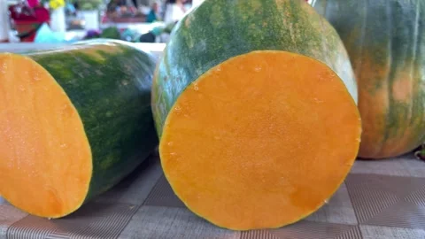 Fresh Pumpkin Cut in Half with Bright Orange Flesh Displayed at Farmers Market 스톡 동영상 345179413