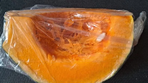 Fresh pumpkin slice wrapped in plastic film for motion video footage Stock Footage 339505159