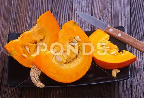 Fresh pumpkin on wooden board on a table Stock Photos