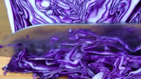 Fresh purple cabbage being precisely sliced with vibrant texture details Stock Footage 331576616