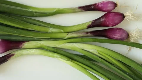 Fresh purple spring onions moving on white background Stock Footage 344604482