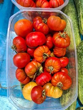 Fresh Raf tomatoes in a plastic container at a farmers market in Spain duri.. Stock Photos