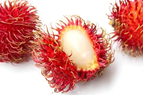 Fresh rambutan fruit split in half with white juicy pulp isolated Stock-Fotos