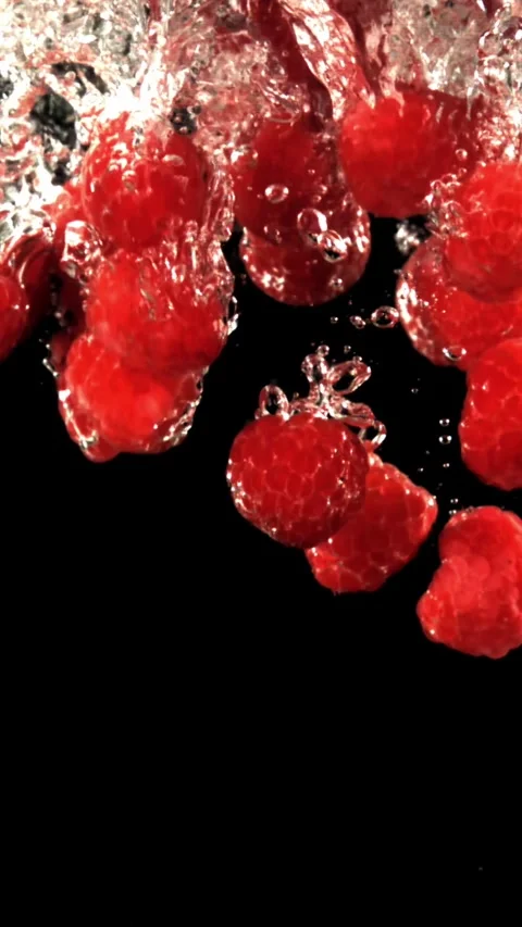 Fresh raspberries fall underwater with bubbles. Filmed is slow motion 1000 fps Stock Footage 335292344