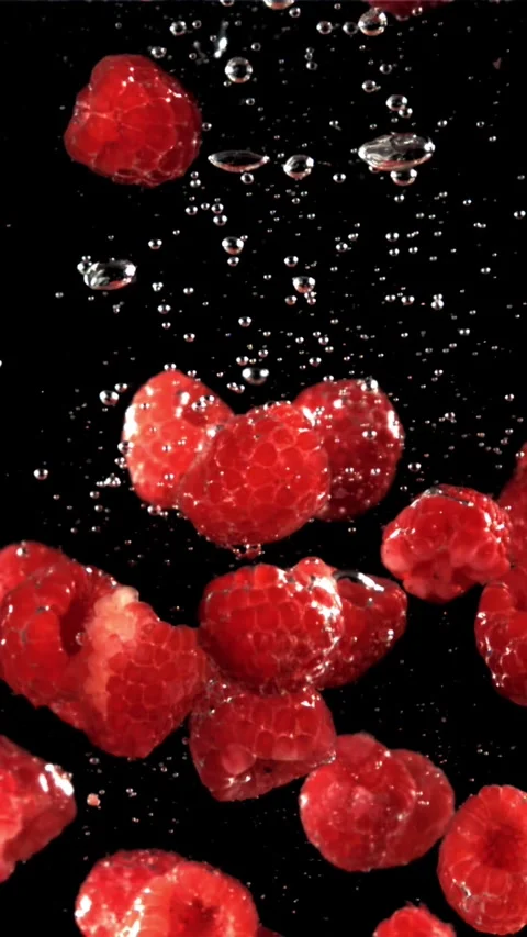 Fresh raspberries fall underwater with bubbles. Filmed is slow motion 1000 fps Stock Footage 335292701