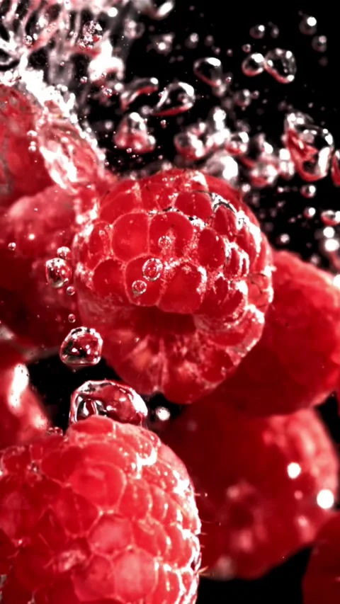 Fresh raspberries fall underwater with bubbles. Filmed is slow motion 1000 fps Stock Footage 335293056