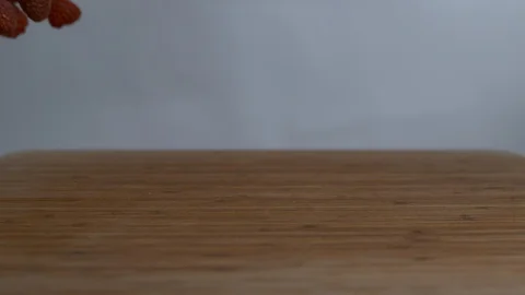 Fresh raspberries falling and bouncing over wooden surface in slow motion Stock Footage 100006594