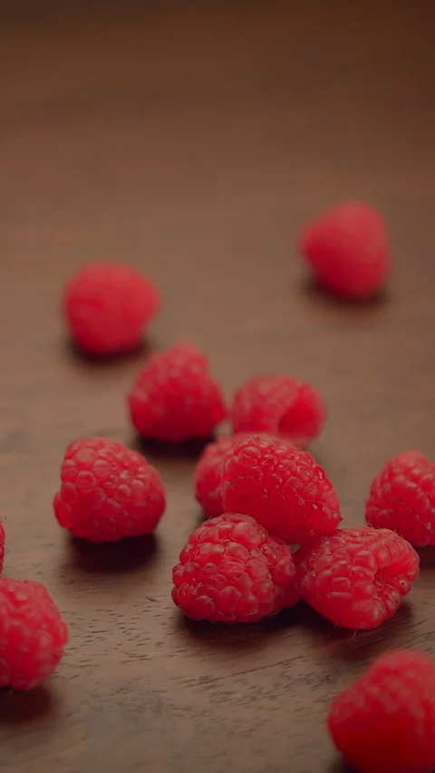 Fresh Raspberries Falling Gracefully on a Beautiful Wooden Surface Stock Footage 287206027