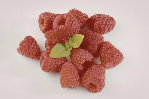 Fresh raspberries with mint leaf on white Stock Photos