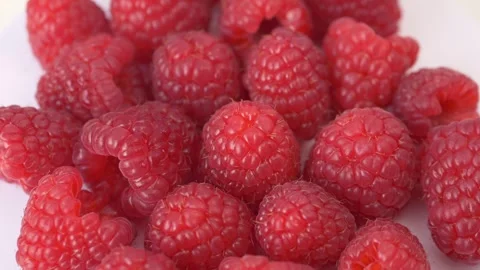 Fresh raspberries rotating on light background highlighting texture, color and Stock Footage 332875727