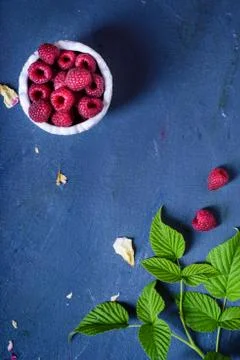 Fresh Raspberry berries, blue background top view, copy space. Stock Photos