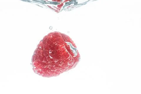 Fresh raspberry falling in water isolated on white background . Healthy food Stock Photos