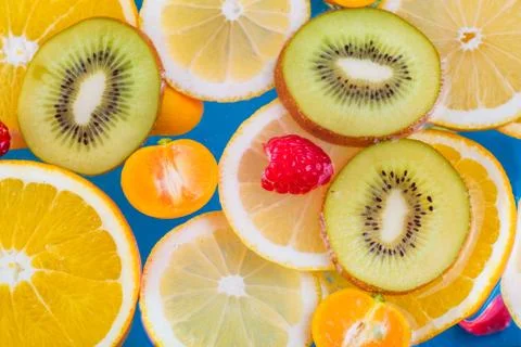 Fresh raspberry, kiwi, orange, lemon and orange slices floating in water on w Foto stock
