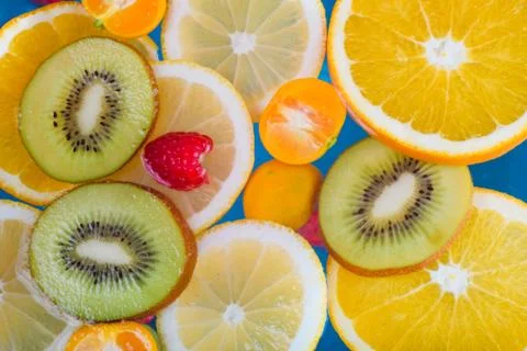 Fresh raspberry, kiwi, orange, lemon and orange slices floating in water on w 스톡 사진