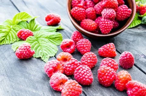 Fresh raspberry with leaves on the background of old dark boards. Selective f Foto stock