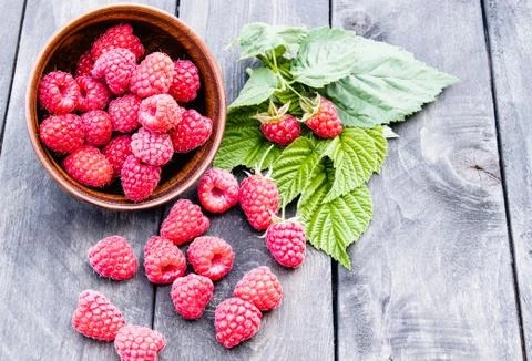 Fresh raspberry with leaves on the background of old dark boards. Selective f Stock Photos