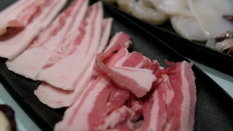 Fresh raw bacon sliced with spices and herbs on a dark concrete background Stock Footage 302090356