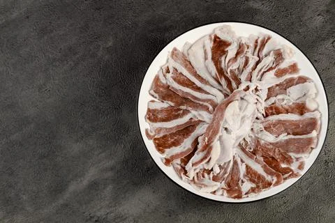 A fresh raw beef cut with rich fat marbling on an elegant black premium plate Stock Photos