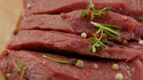 Fresh raw beef meat close-up with seasonings - peppers, salt. Preparation for Stock Footage 90495426