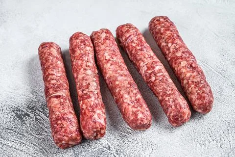 Fresh raw beef meat kebabs sausages. White background. Top view Stock Photos