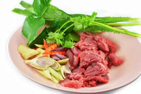 Fresh raw beef meat slice on bowl with herbs and vegetables Stock Photos