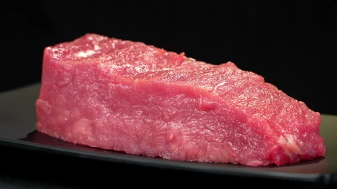Fresh Raw Beef Tenderloin Tilted on Black Plate Stock-Footage 343263179