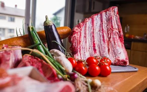 Fresh Raw Beef with Vegetables on Kitchen Table Foto stock