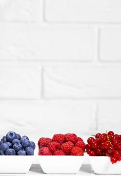 Fresh Raw Berries in white ceramic bowl on white background. Space for text. Stock Photos