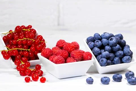 Fresh Raw Berries in white ceramic bowl on white background. Space for text. Stock Photos
