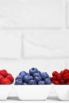 Fresh Raw Berries in white ceramic bowl on white background. Space for text. Stock Photos