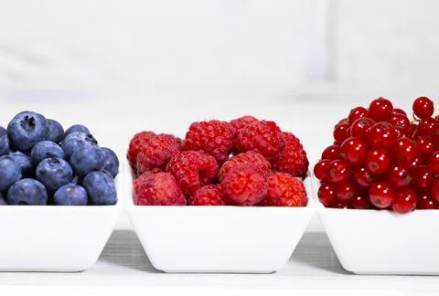 Fresh Raw Berries in white ceramic bowl on white background. Space for text Stock Photos