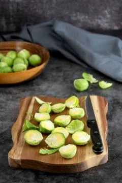 Fresh raw brussels sprouts on a wooden cuting board, dark background. Healthy Stock Photos