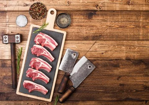 Fresh raw butchers lamb beef cutlets on chopping board with vintage meat Stock Photos