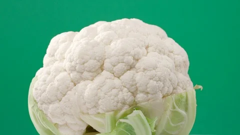 Fresh raw cauliflower rotating over green background Stock Footage 119618683