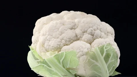 Fresh raw cauliflower rotating over black background Stock Footage 119619330