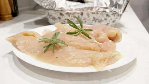 Fresh raw chicken breast fillets sprinkled with peppercorns and rosemary rotates Stock Footage 294747321