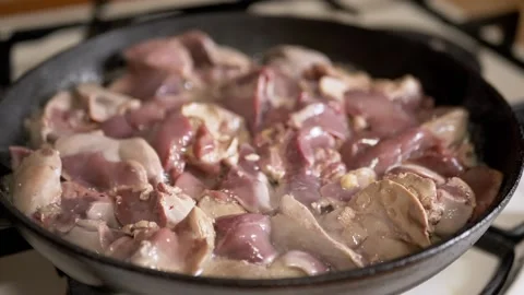 Fresh Raw Chicken Livers Searing in a Cast Iron Skillet on a Stovetop Stock Footage 339067606
