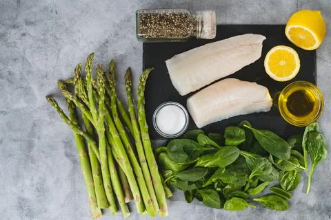 Fresh raw cod fillet, fresh spinach and asparagus, seasoning, olive oil, an.. Stock-Fotos