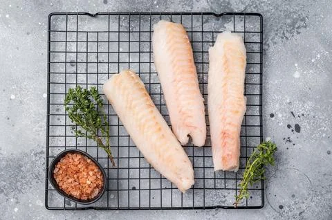Fresh raw cod fish fillet, Boneless white fish meat. gray background. top vie Stock Photos