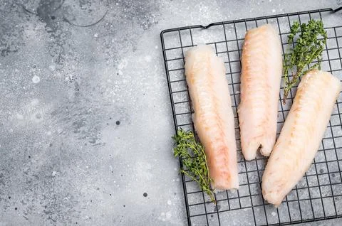 Fresh raw cod fish fillet, Boneless white fish meat. gray background. top vie Stock Photos
